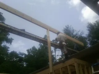 Carpenter setting a ridge beam over a new addition frame — Ice Dam Removal by Roofing Brothers in Startex