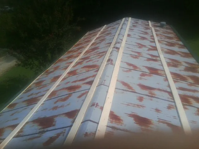 Rusted metal roof panels with new wood purlins before replacement — Storm Damage Roof Repair in Startex by Roofing Brothers