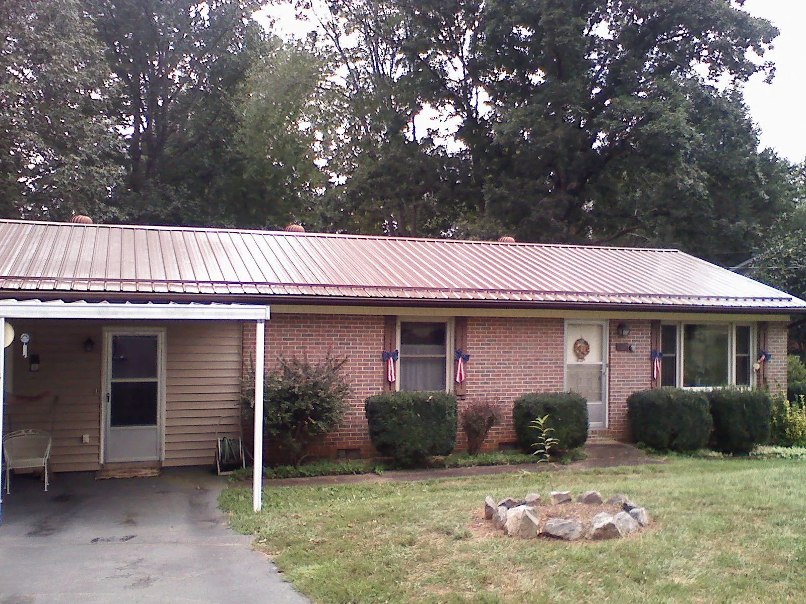 Bronze metal roof and carport on a brick ranch home — Roof Repair work by our crew in Startex